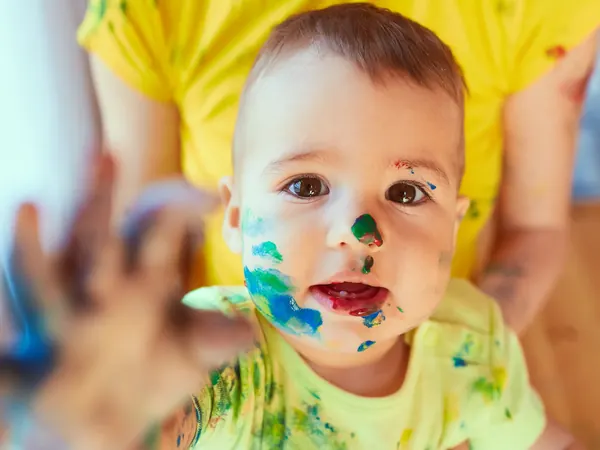 Baby mit bunter Farbe im Gesicht